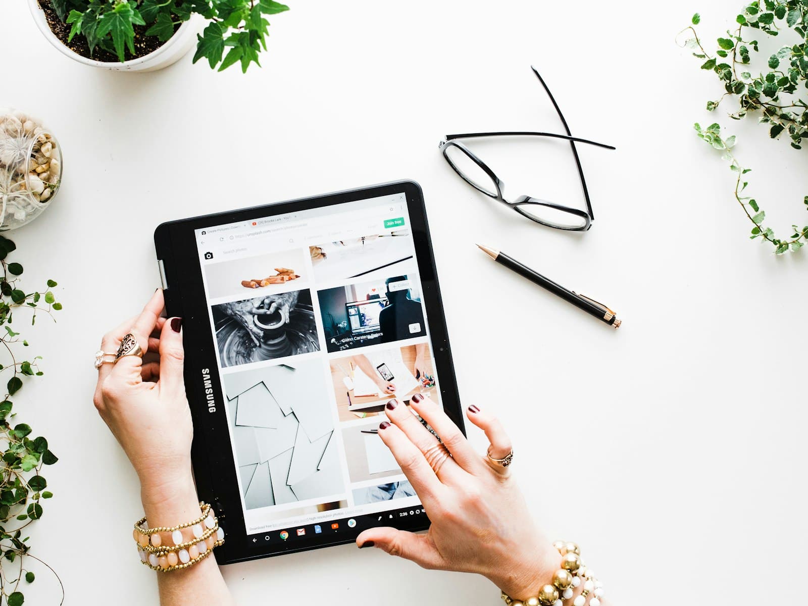 Hands browsing an online store on a tablet on a white desk