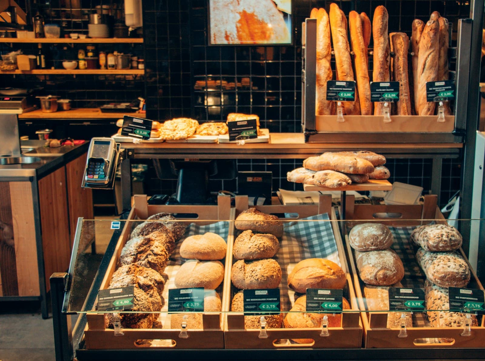 A bakery counter stacked with fresh bread, pastries and baguettes