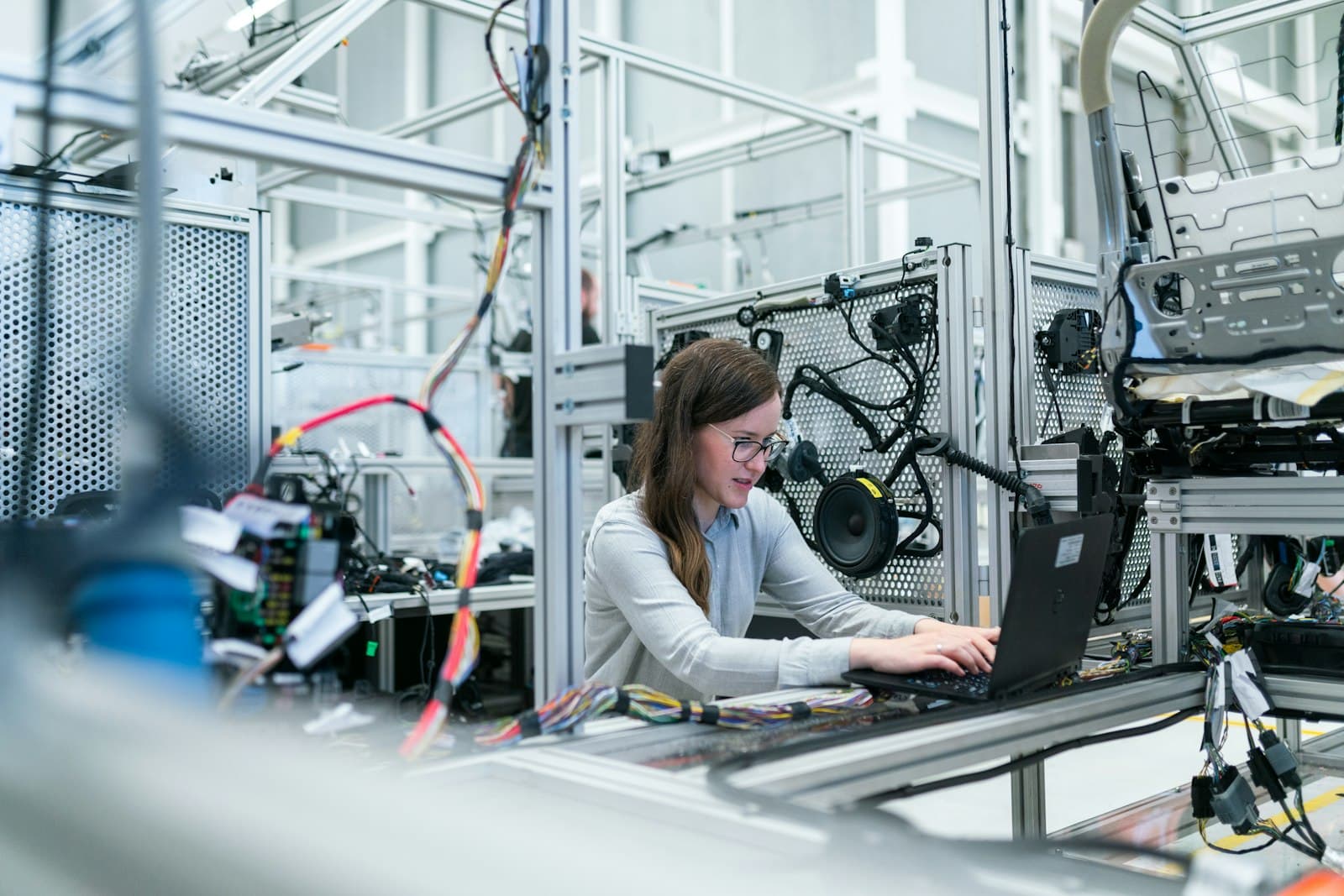An engineer working at a laptop inside an industrial automation lab