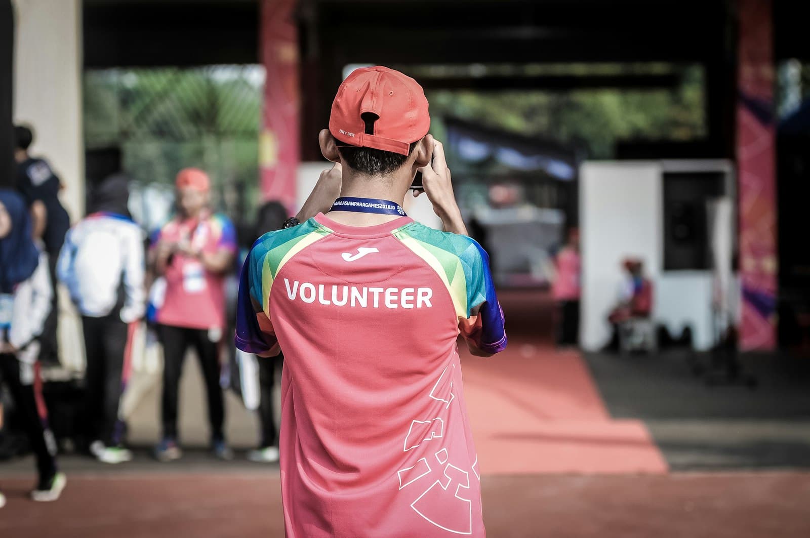 A volunteer in a bright jersey marked “Volunteer” at an outdoor event