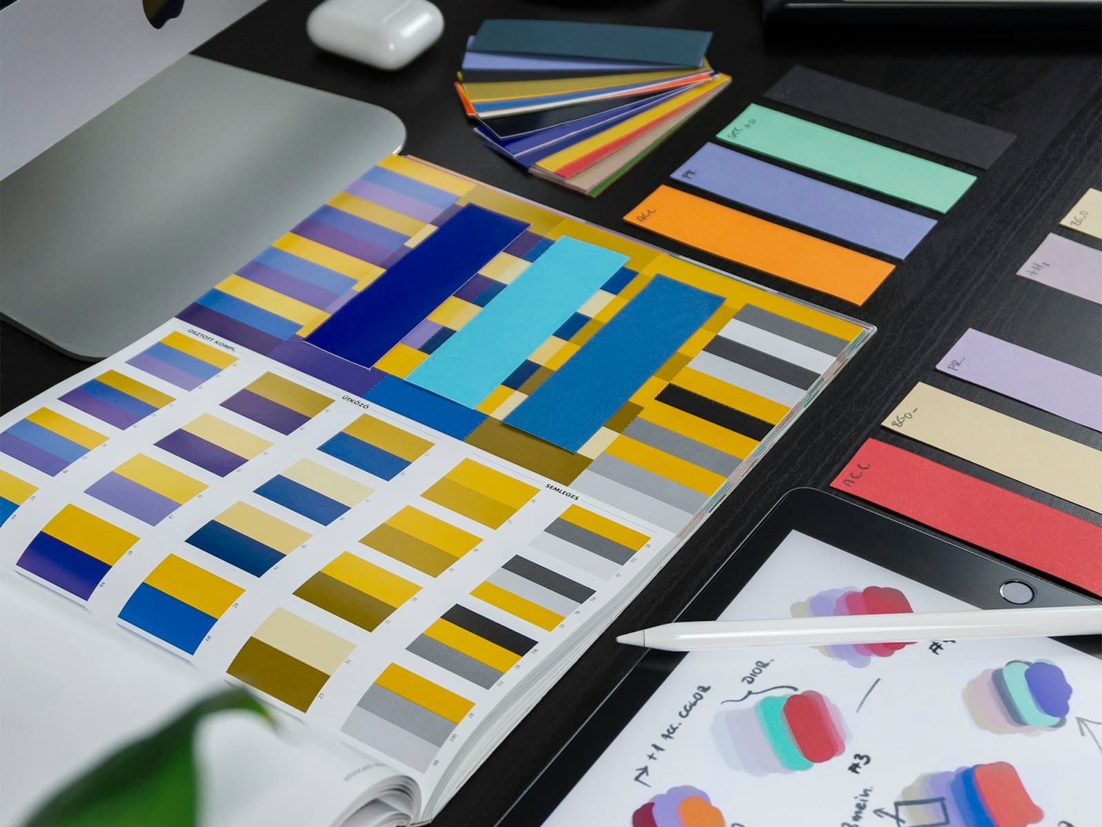 Colour swatches and a tablet with design sketches on a desk